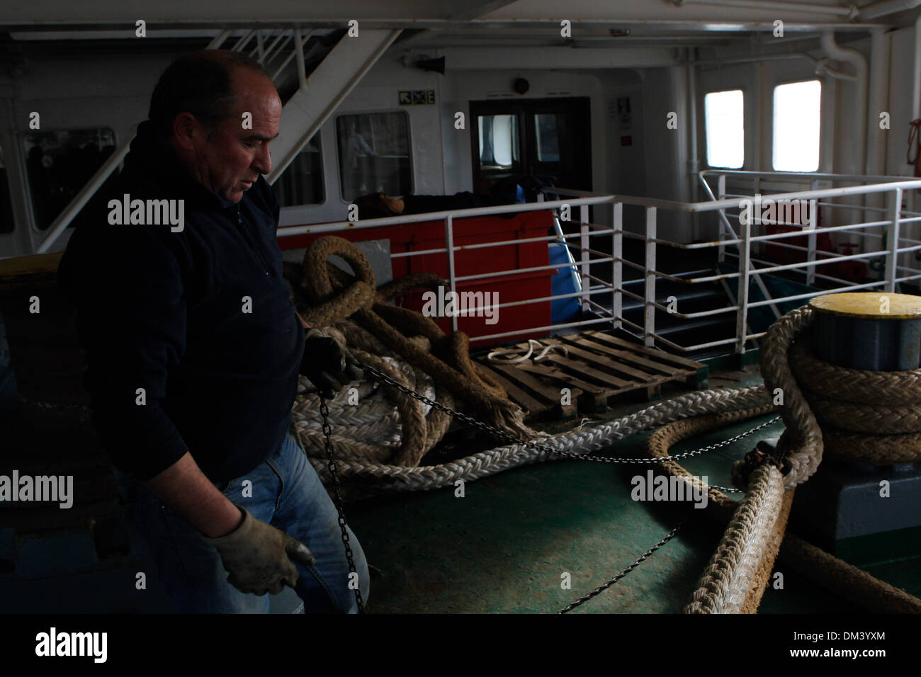 Ship crew guiding heavy duty mooring rope during docking procedure ...