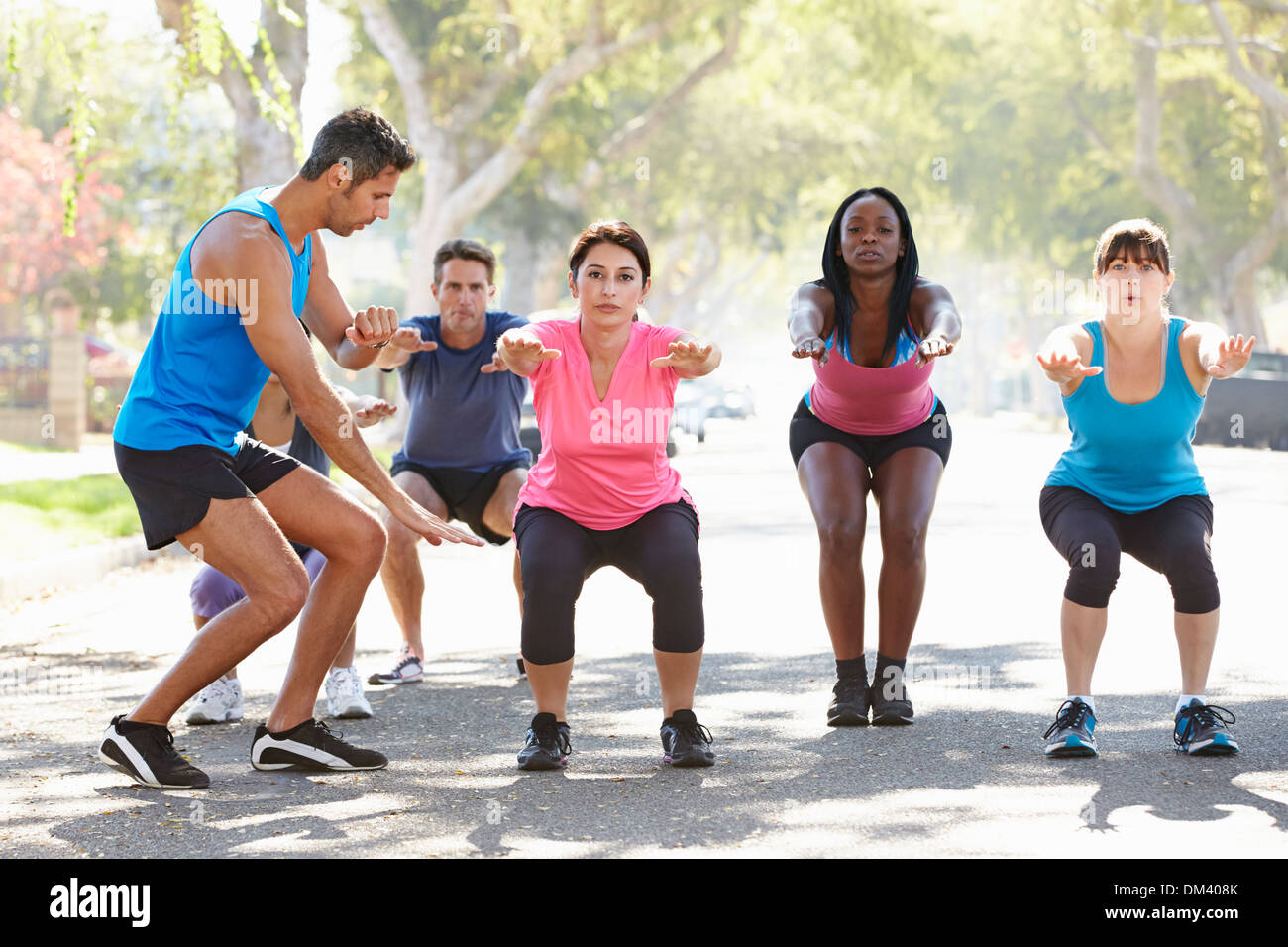 Group Of People Exercising Street With Personal Trainer Stock Photo