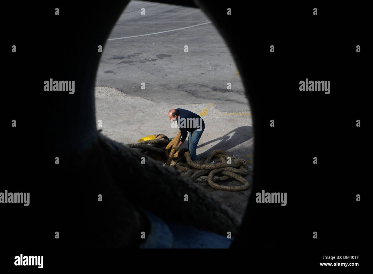 Ship crew guiding heavy duty mooring rope during docking procedure ...