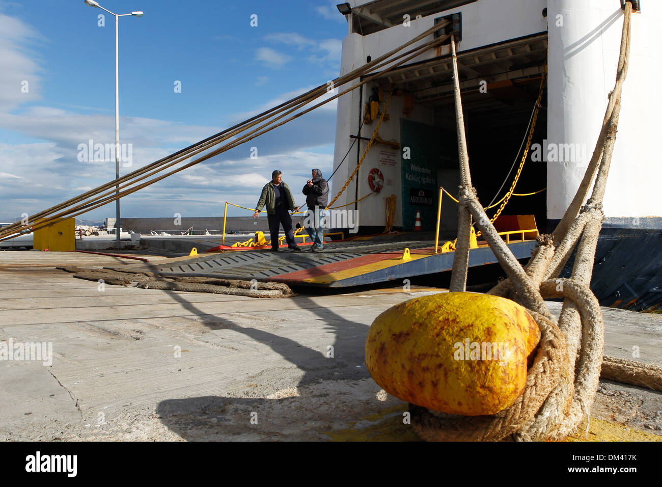 Ship crew guiding heavy duty mooring rope during docking procedure ...
