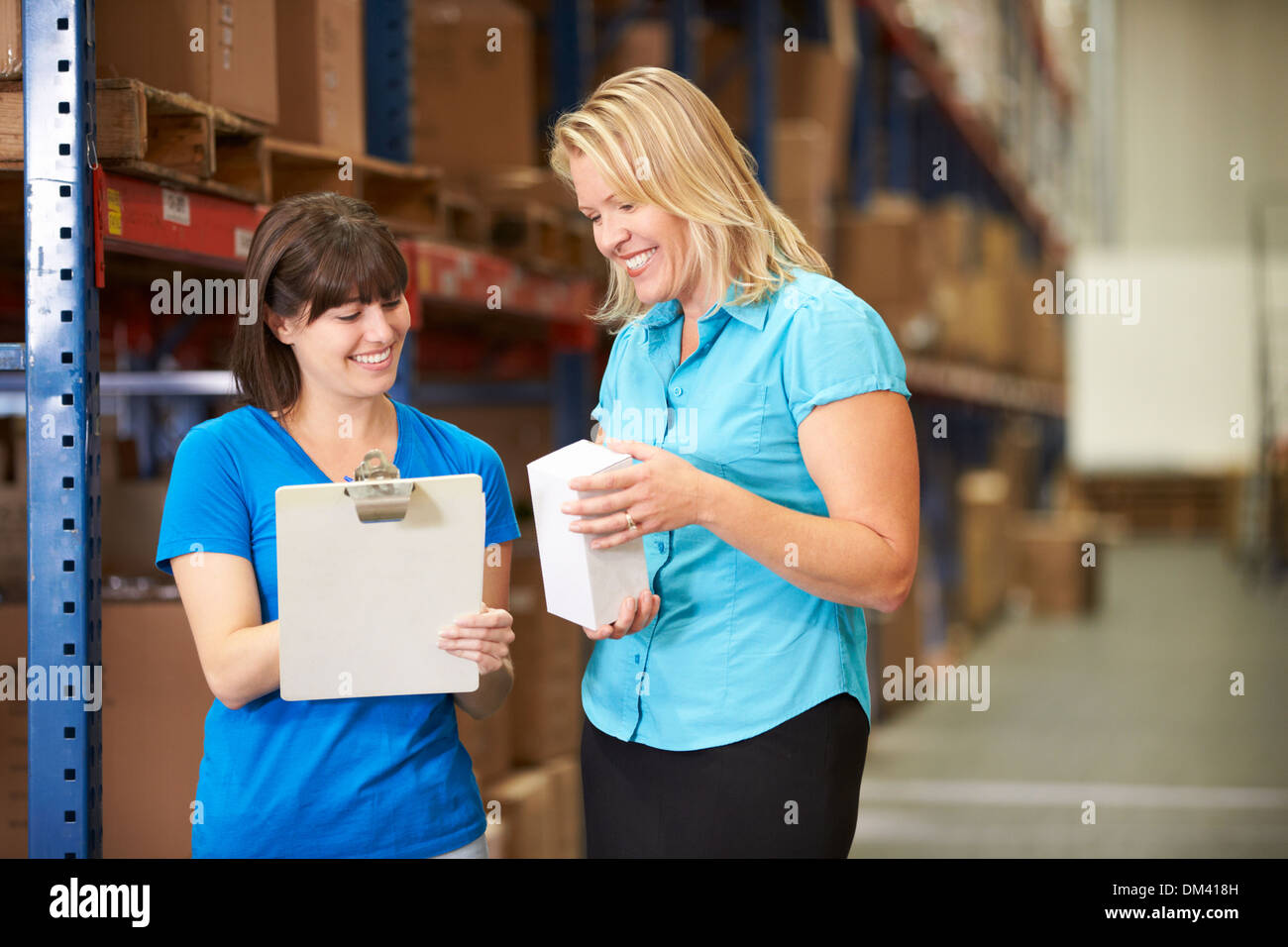 Businesswoman And Female Worker In Distribution Warehouse Stock Photo