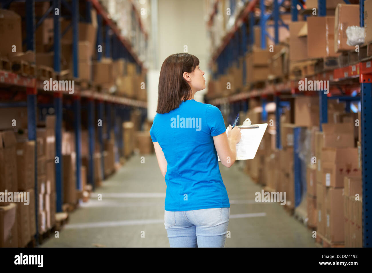 Rear View Of Female Worker In Distribution Warehouse Stock Photo
