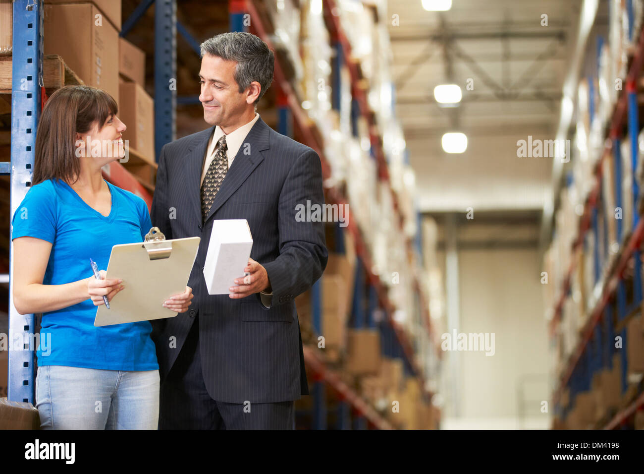 Businessman And Female Worker In Distribution Warehouse Stock Photo