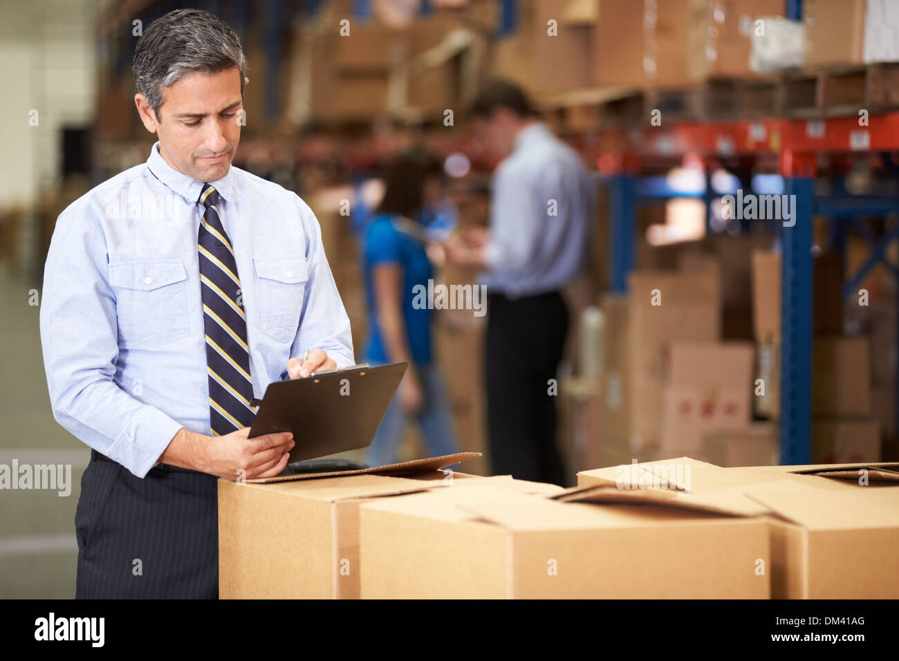 Manager In Warehouse Checking Boxes Stock Photo