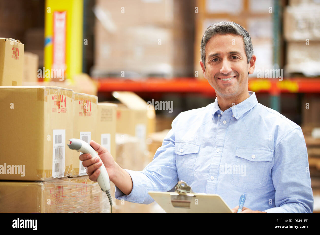 Worker Scanning Package In Warehouse Stock Photo