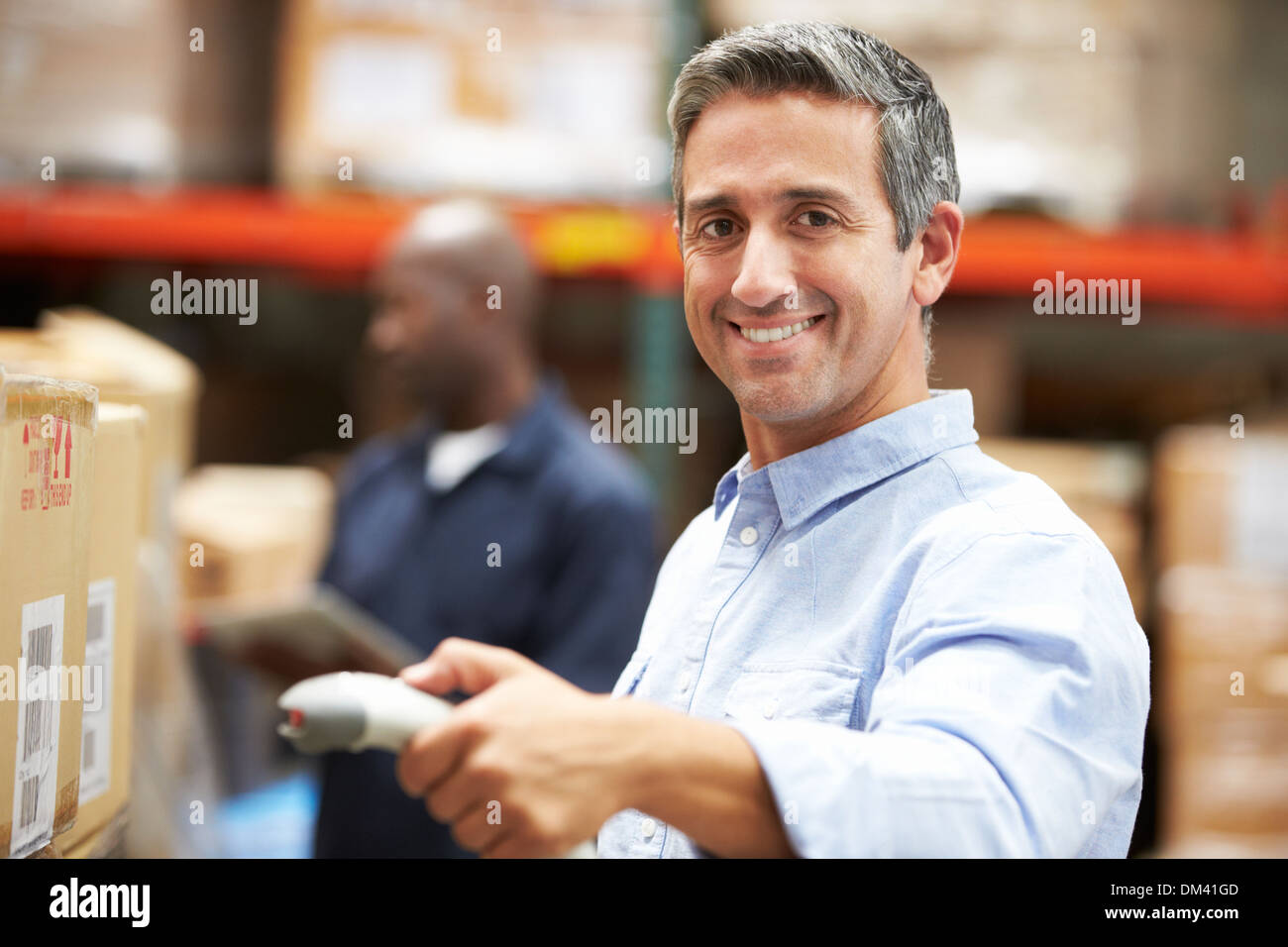 Worker Scanning Package In Warehouse Stock Photo