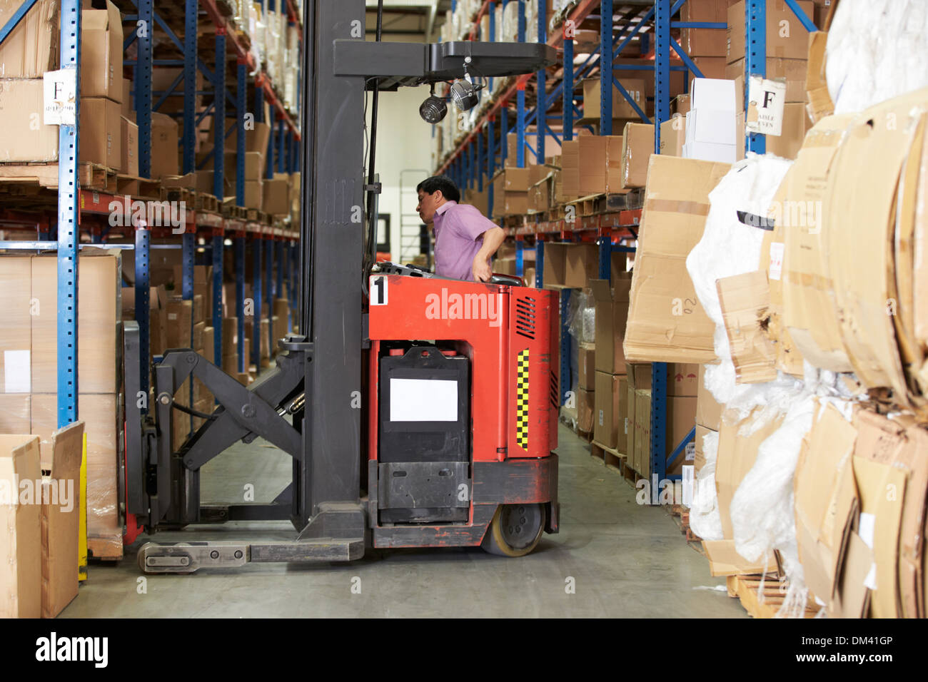 Man Driving Fork Lift Truck In Warehouse Stock Photo