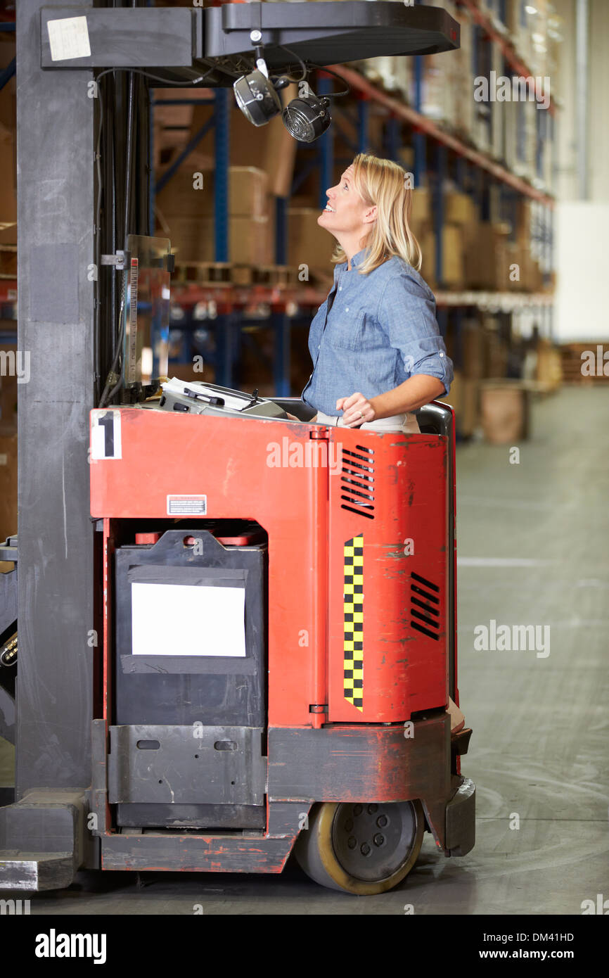 Woman Driving Fork Lift Truck In Warehouse Stock Photo