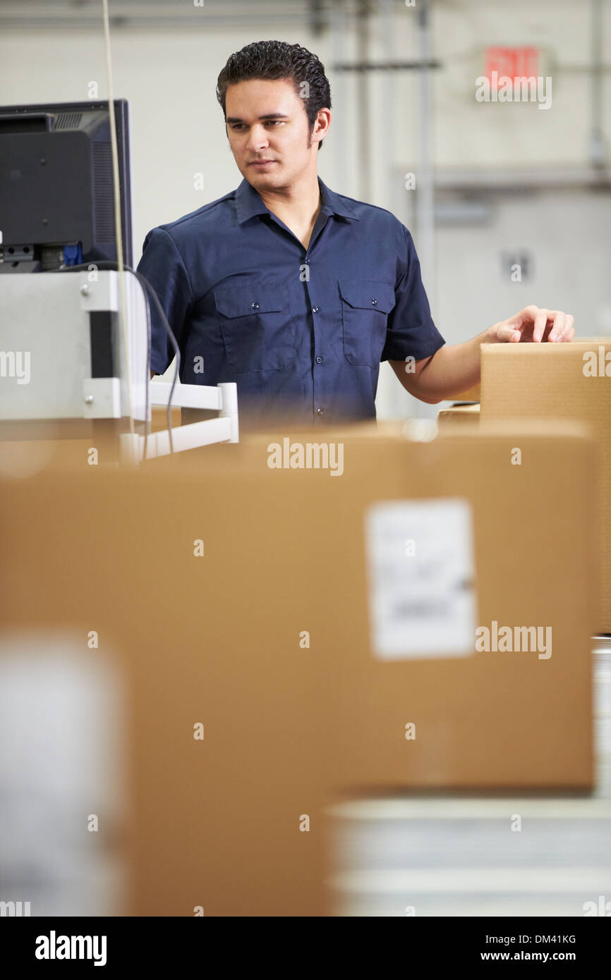 Worker Checking Goods On Belt In Distribution Warehouse Stock Photo