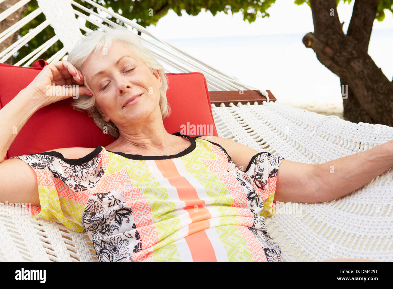 Senior Woman Relaxing In Beach Hammock Stock Photo - Alamy