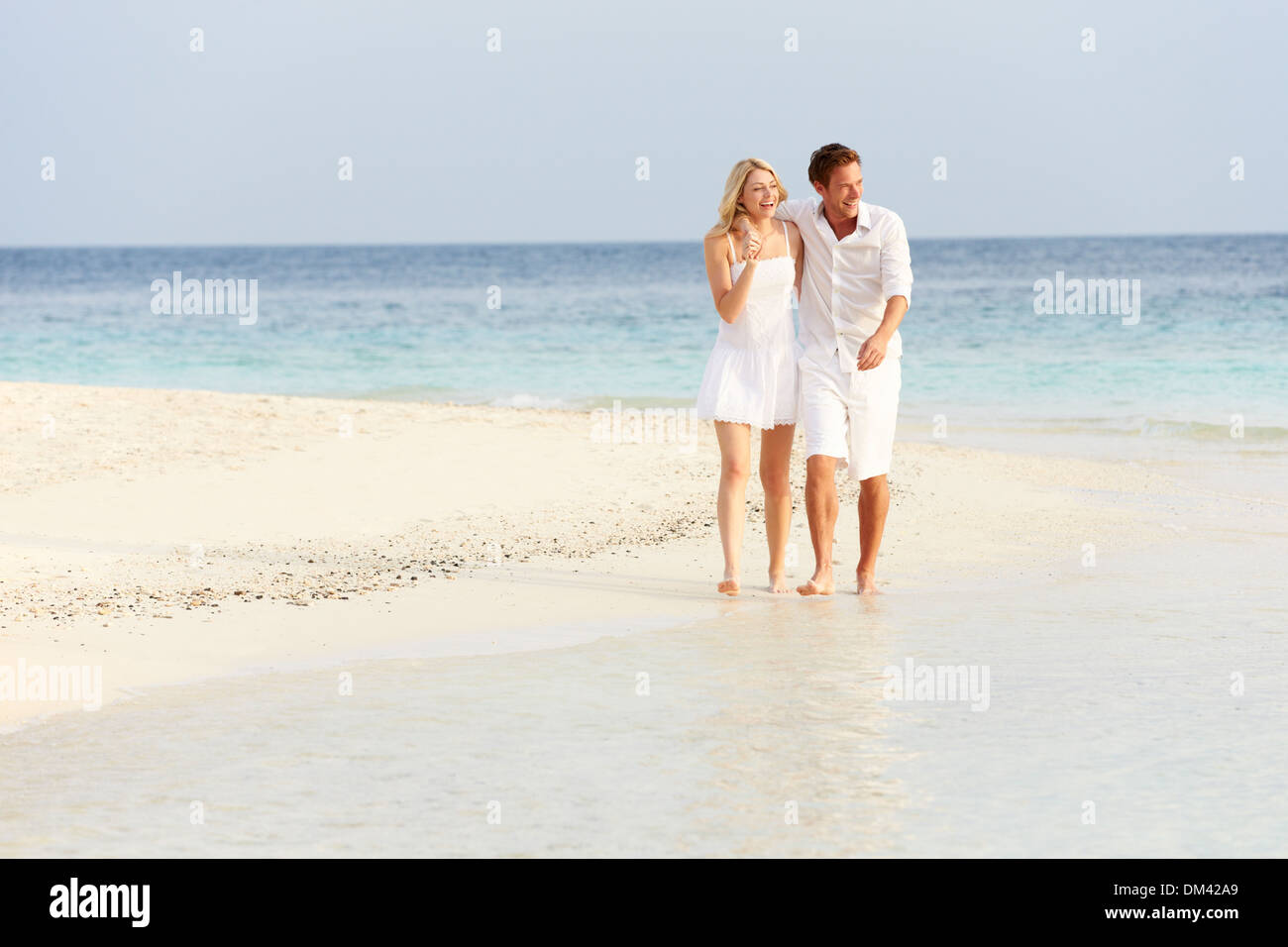 Romantic Couple Walking On Beautiful Tropical Beach Stock Photo