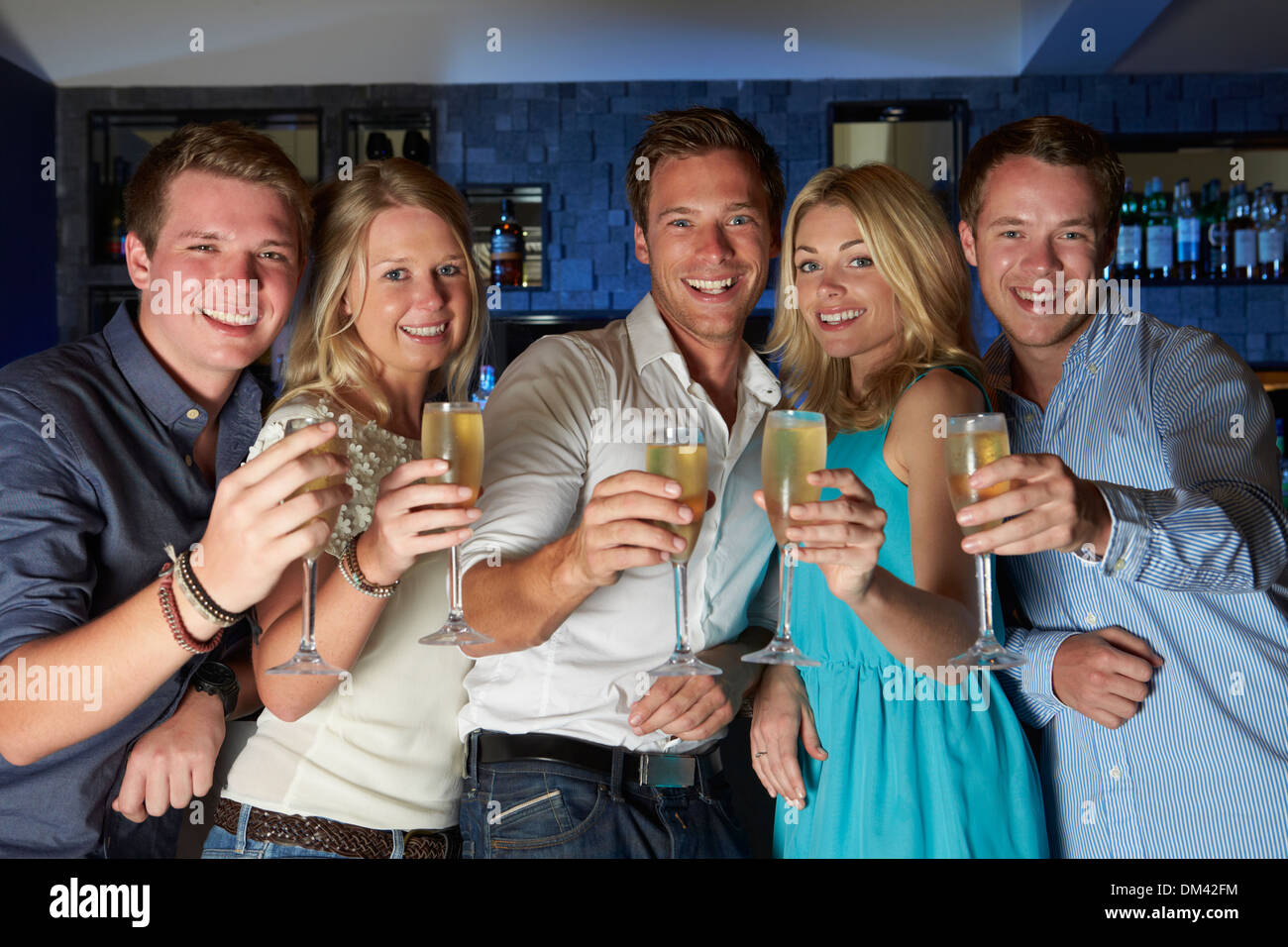 Group Of Friends Enjoying Glass Of Champagne In Bar Stock Photo