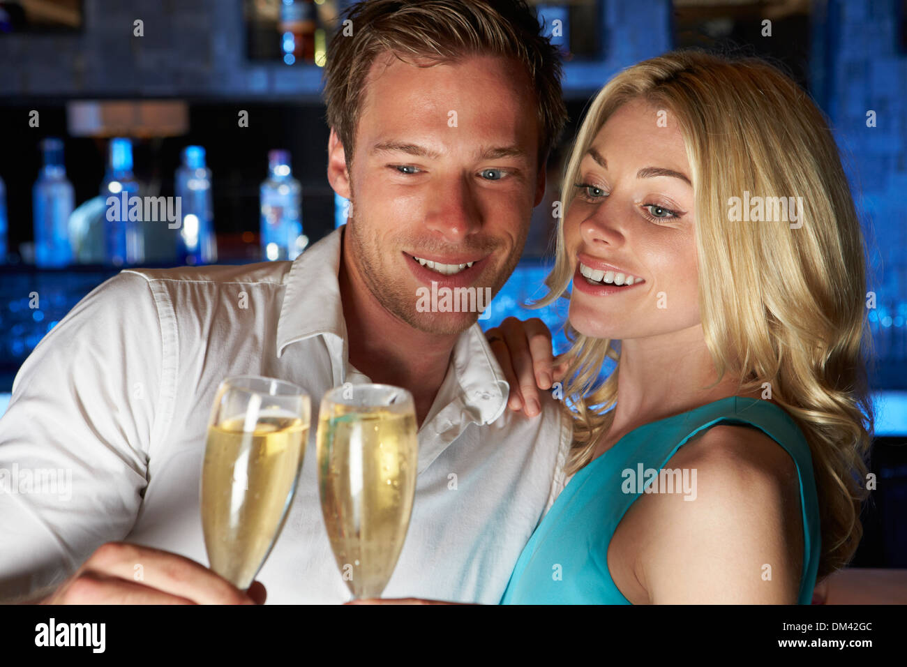 Couple Enjoying Glass Of Champagne In Bar Stock Photo