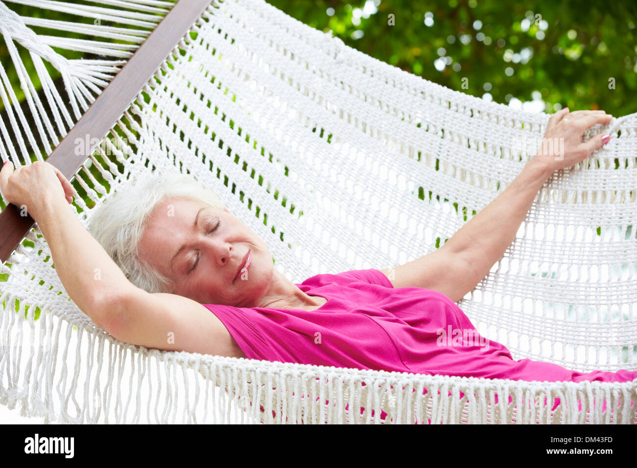 Senior Woman Relaxing In Beach Hammock Stock Photo - Alamy