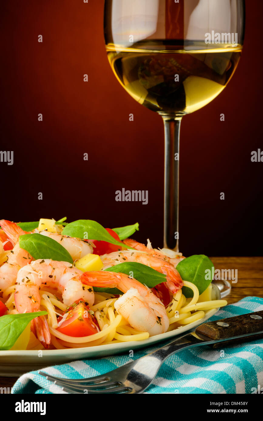 italian spaghetti pasta with fresh shrimps and glass of white wine Stock Photo