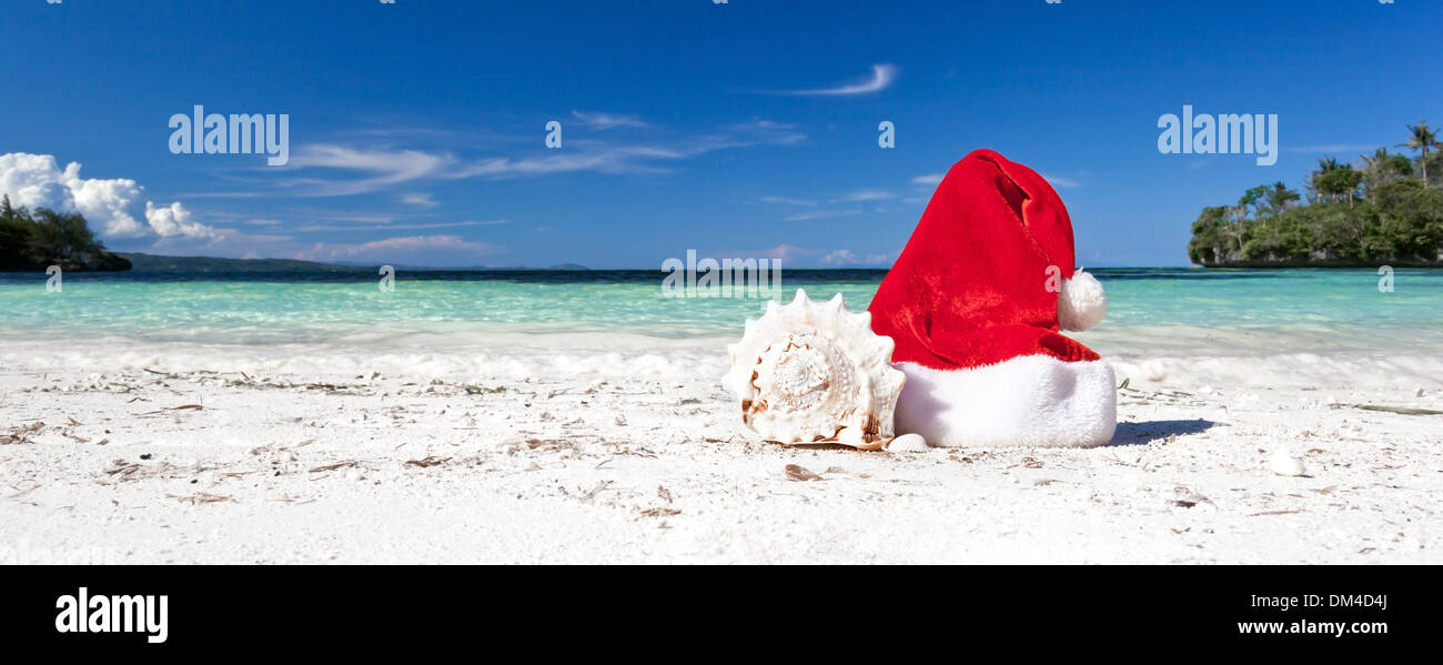 Red Santa Claus hat on beach with seashell, Travel Christmas concept ...