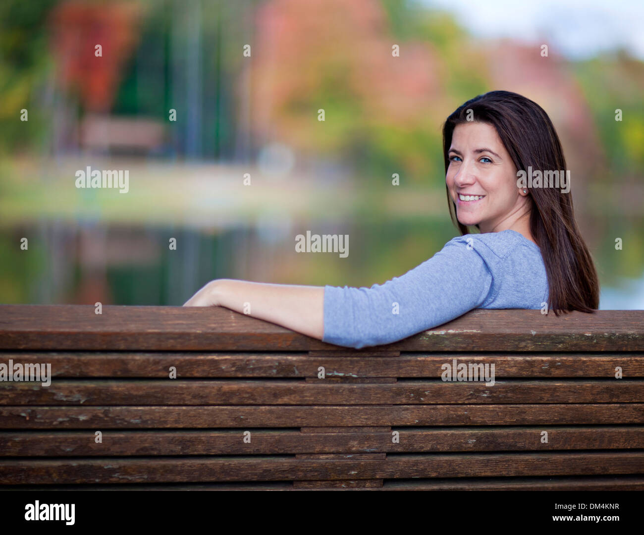 Beautiful woman sitting outdoors on a park bench in the fall Stock ...