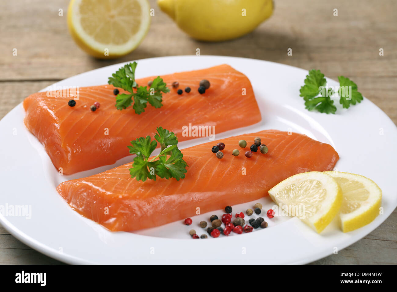Smoked salmon fish on a plate served with a lemon Stock Photo