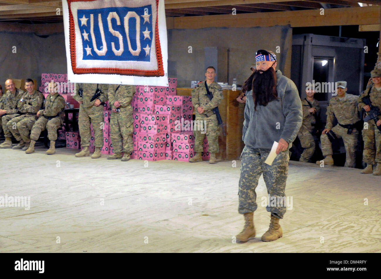 Camp Leatherneck, Helmand, Afghanistan. 10th December 2013. Chairman of the Joint Chiefs General Martin E. Dempsey, right, wears a fake beard as he walks on stage to join Duck Dynasty reality television star Willie Robertson December 10, 2013 at Kandahar Airfield, Kandahar province, Afghanistan. The visit was part of the USO Holiday Tour. Credit:  Planetpix/Alamy Live News Stock Photo