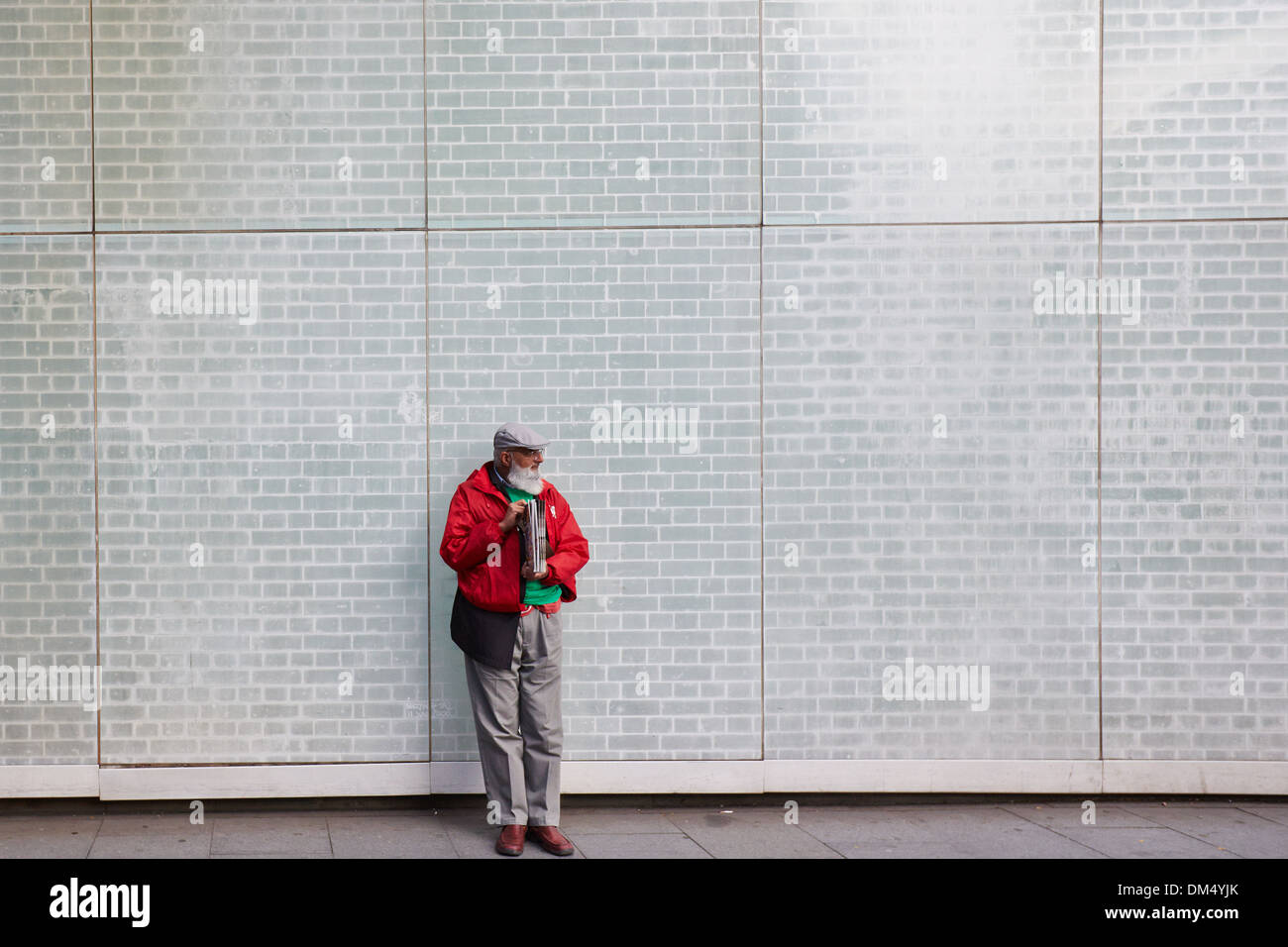 Big issue seller leaning against a wall in an underpass near Waterloo Station Stock Photo