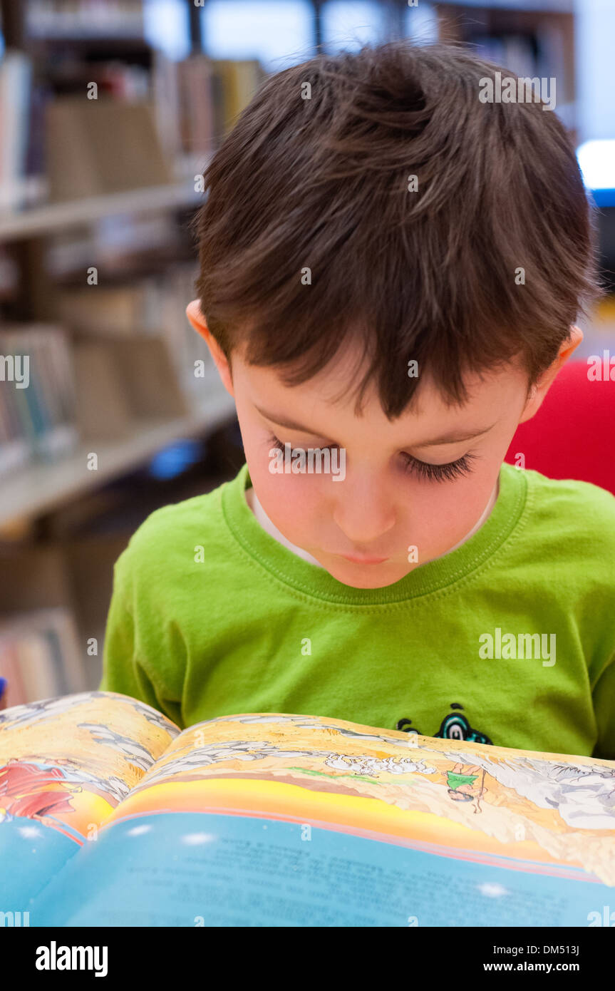 Child reading at public library Stock Photo