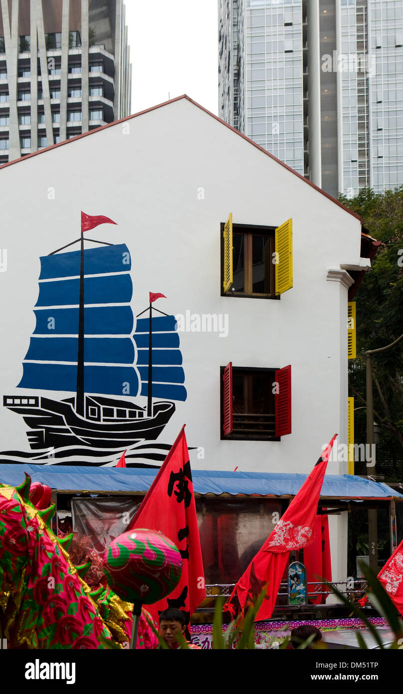 A mural of a boat painted on the side of a building in Chinatown contrasts with the skyscrapers in Singapore. Stock Photo