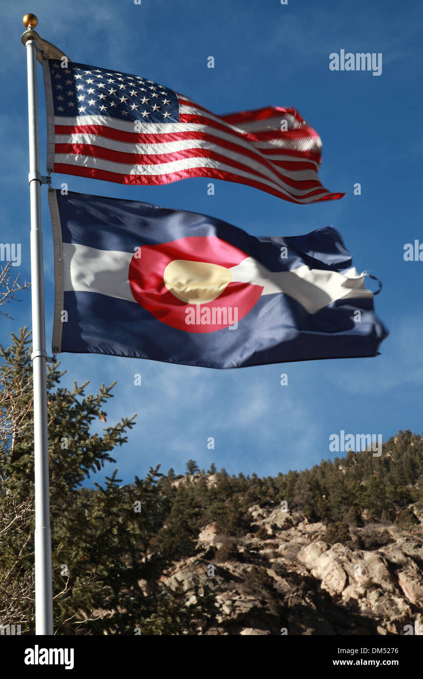 United states of America State Flag and the state of Colorado flag against the Rockie Mountains Stock Photo