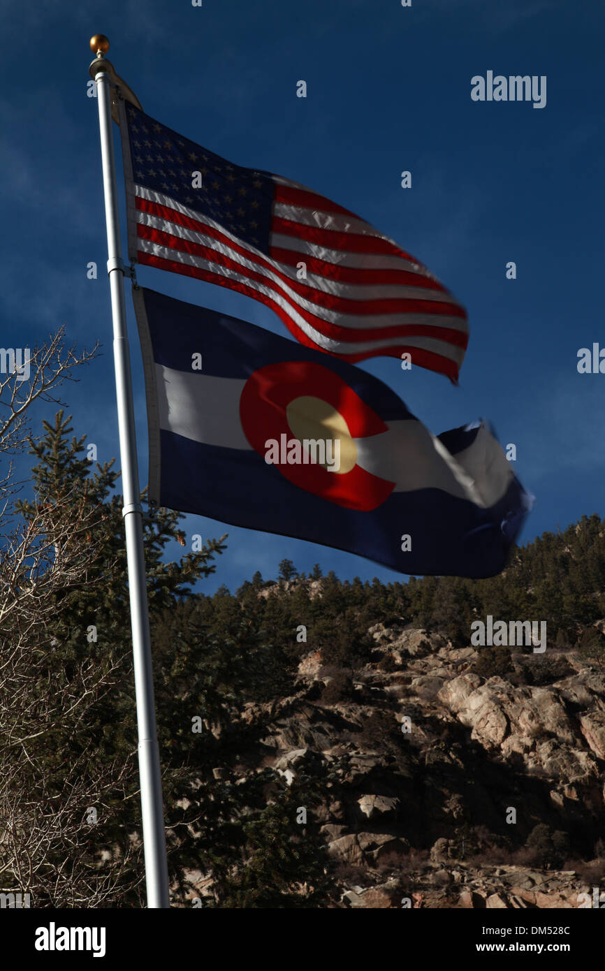 United states of America State Flag and the state of Colorado flag against the Rockie Mountains Stock Photo