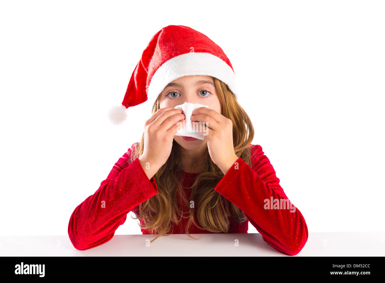 Christmas Santa kid girl blowing her nose in a winter cold isolated on white background Stock Photo