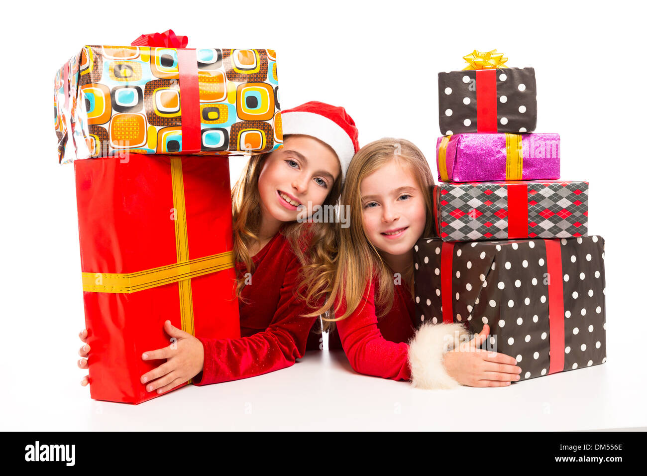 Christmas Santa kid girls with many gifts stacked isolated on white Stock Photo