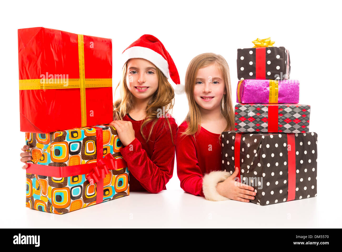 Christmas Santa kid girls with many gifts stacked isolated on white Stock Photo