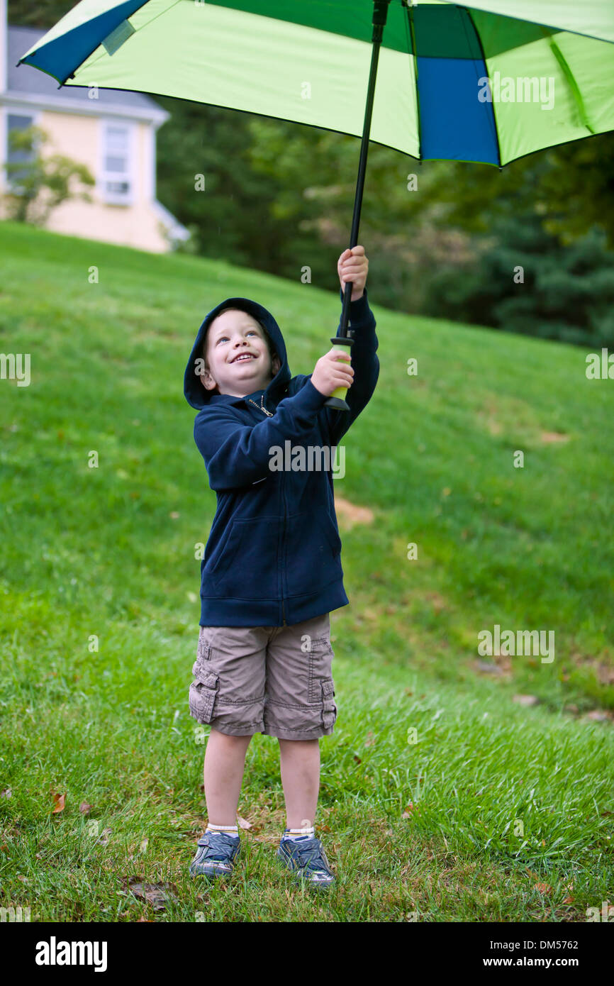 Young boy holding umbrella in air outside Stock Photo Alamy