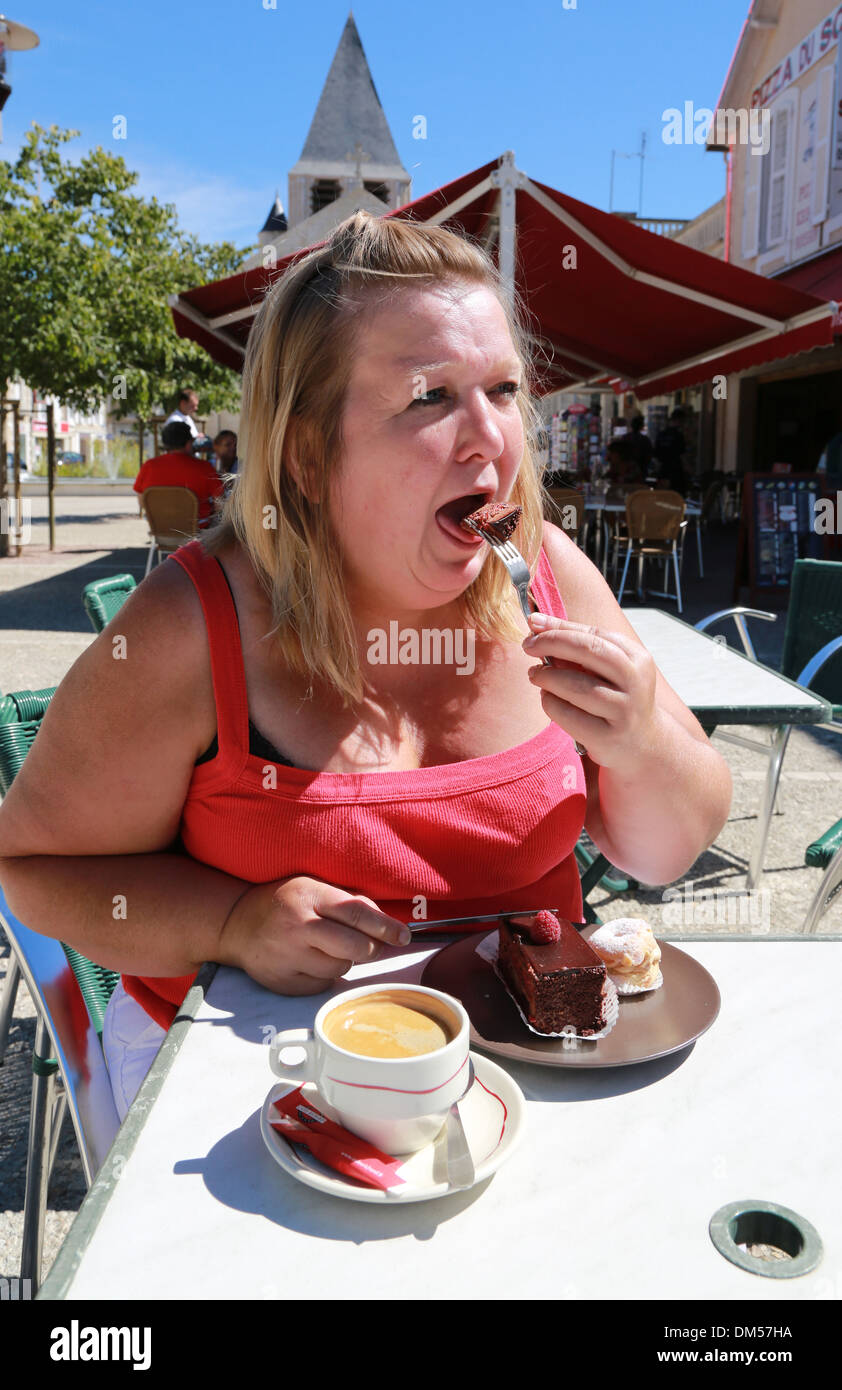 Fat woman eating cake. Stock Photo