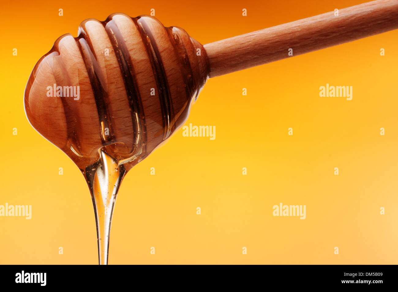 Honey dripping from a wooden honey Stock Photo Alamy