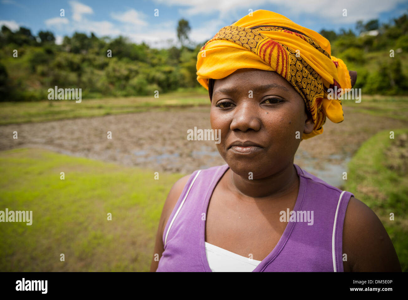 A small farmer stands in her rice field in rural Fenerive Est District
