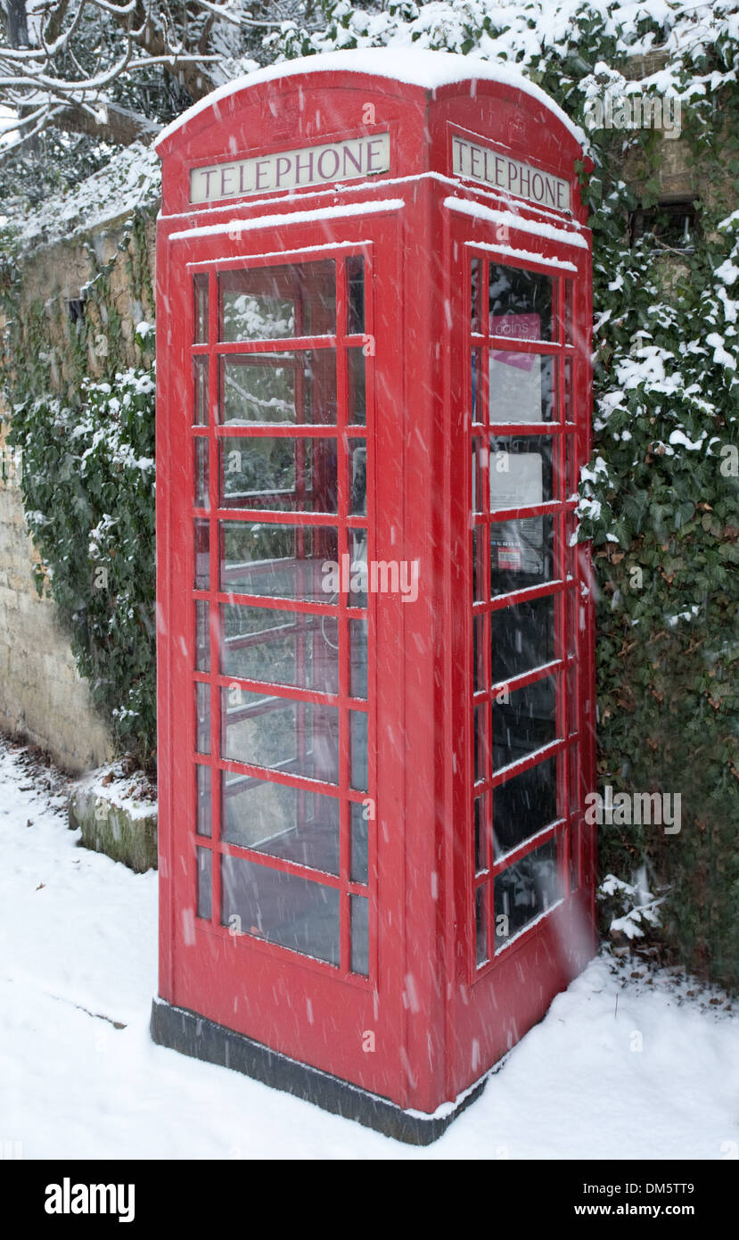 Winter Telephone English red telephone box in winter snow against an ivy clad Cotswold ...