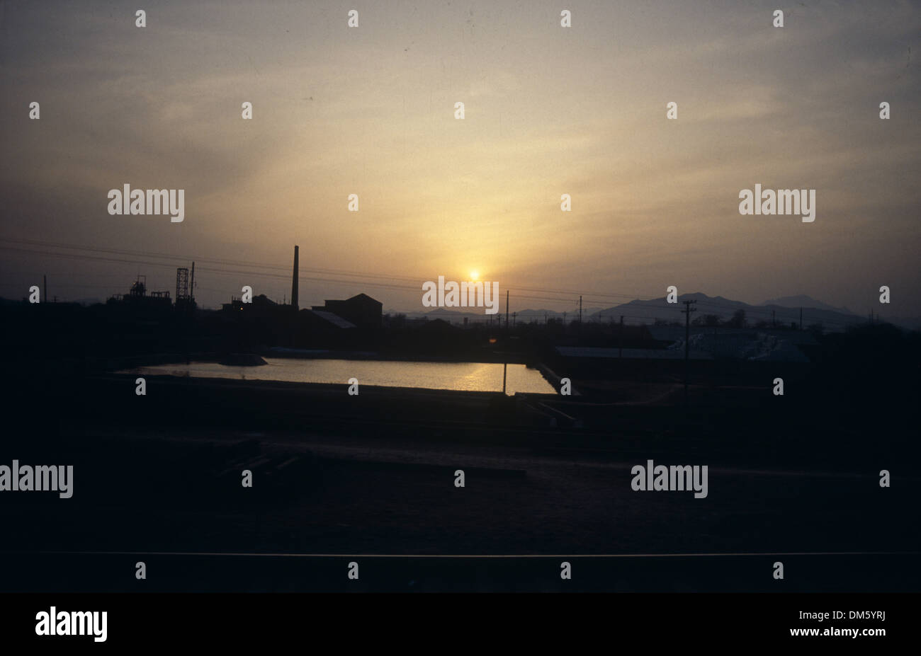 Sunset scenery with a small pond near a farmland in China Stock Photo