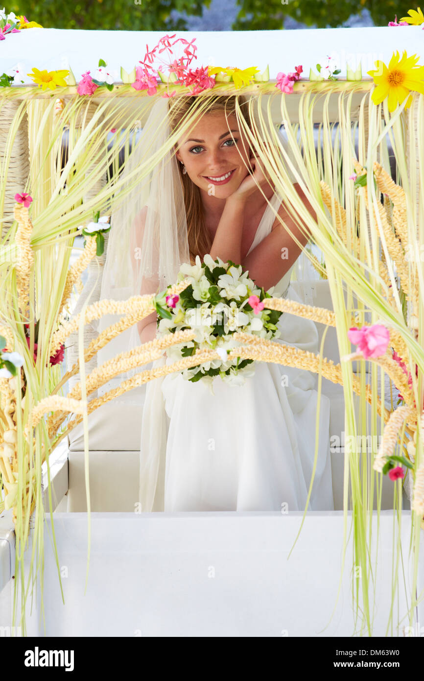 Bride Sitting Under Decorated Canopy At Wedding Stock Photo
