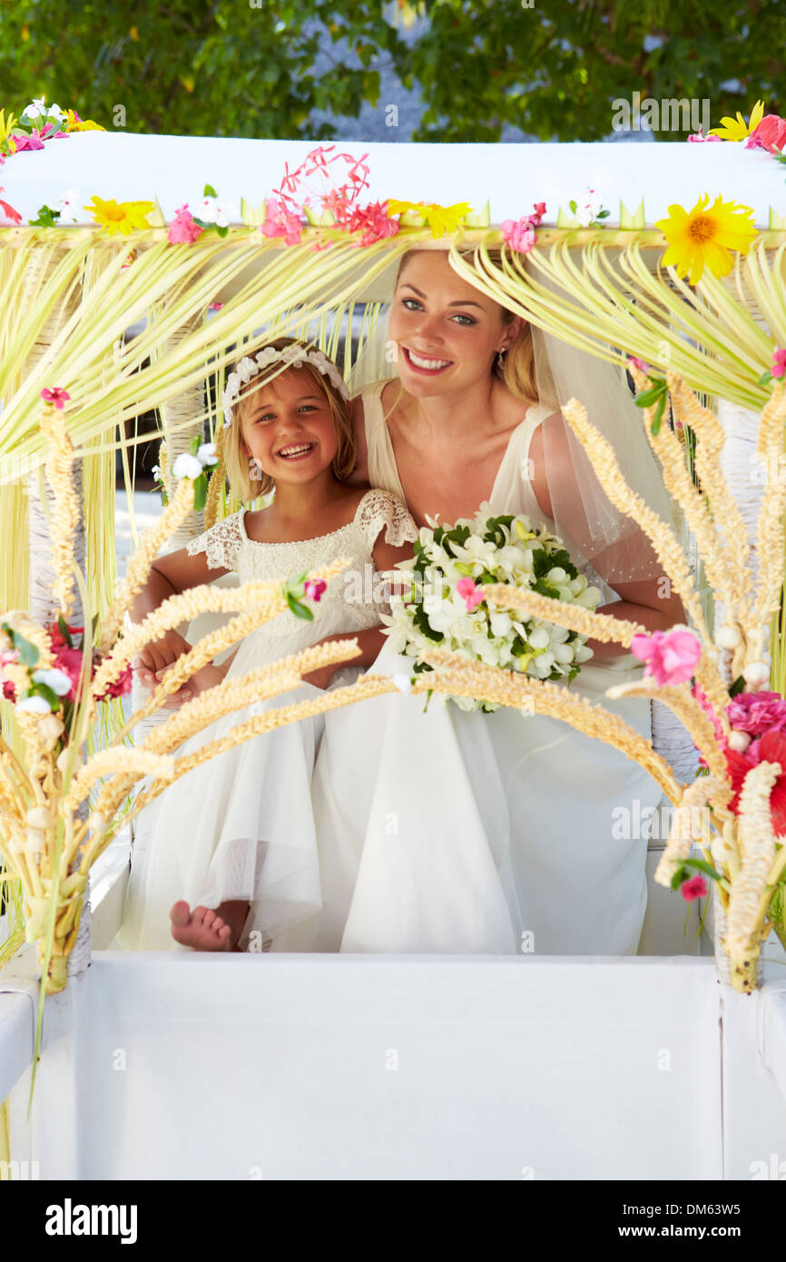 Bride And Bridesmaid Sitting Under Decorated Canopy Stock Photo