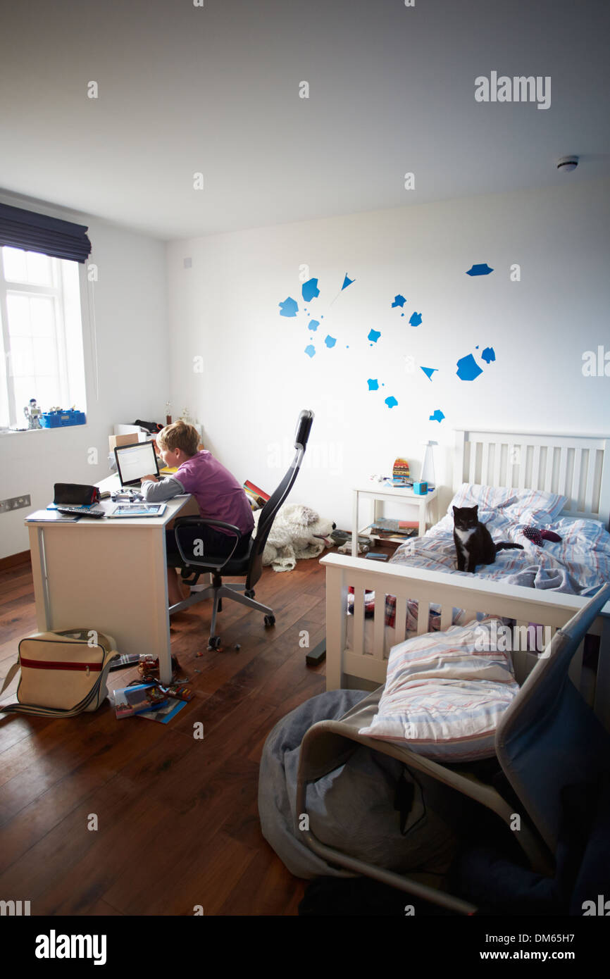Boy Using Laptop In Bedroom Stock Photo - Alamy