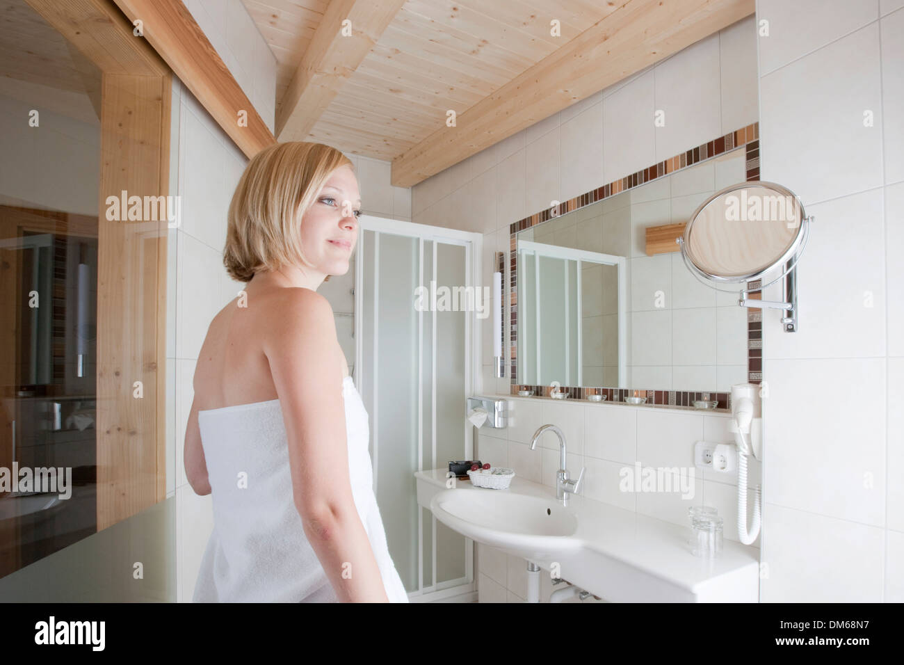 Woman standing in a bathroom Stock Photo