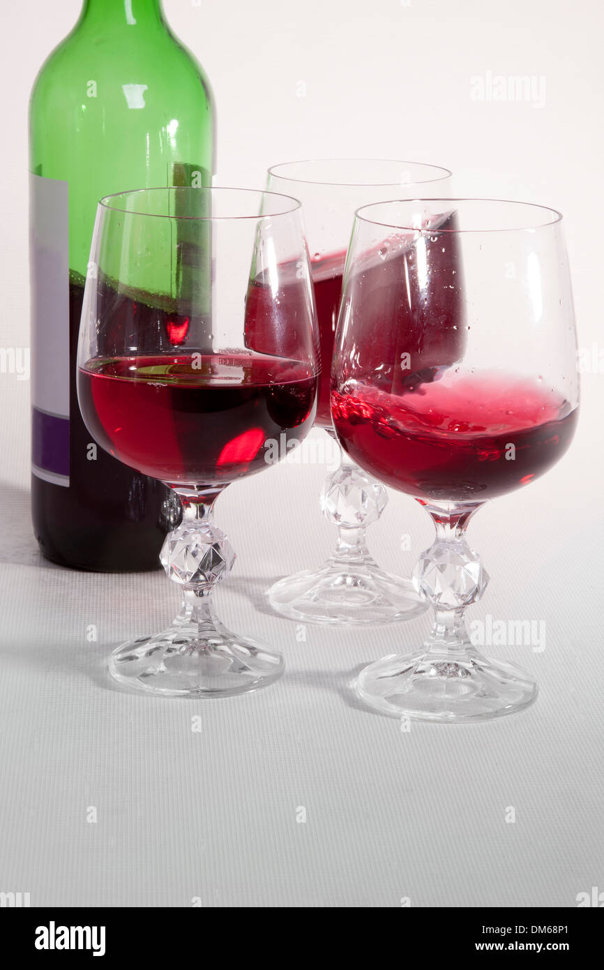 Red wine poured in three glasses. Stock Photo