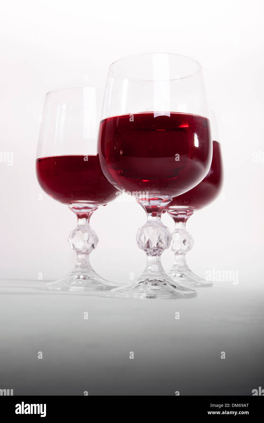 Red wine poured in three glasses. Stock Photo