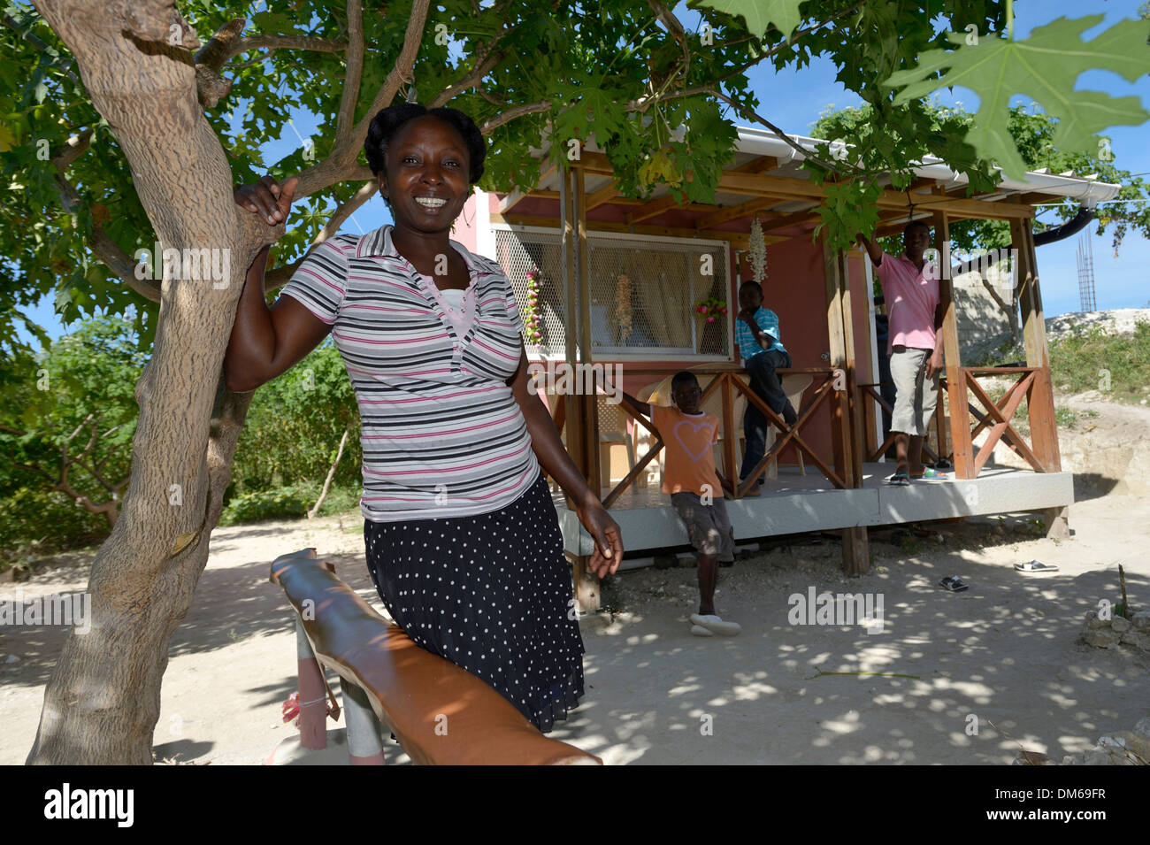 Woman standing in front of the house which she received from an aid organisation after the earthquake, village of Tchawa Stock Photo