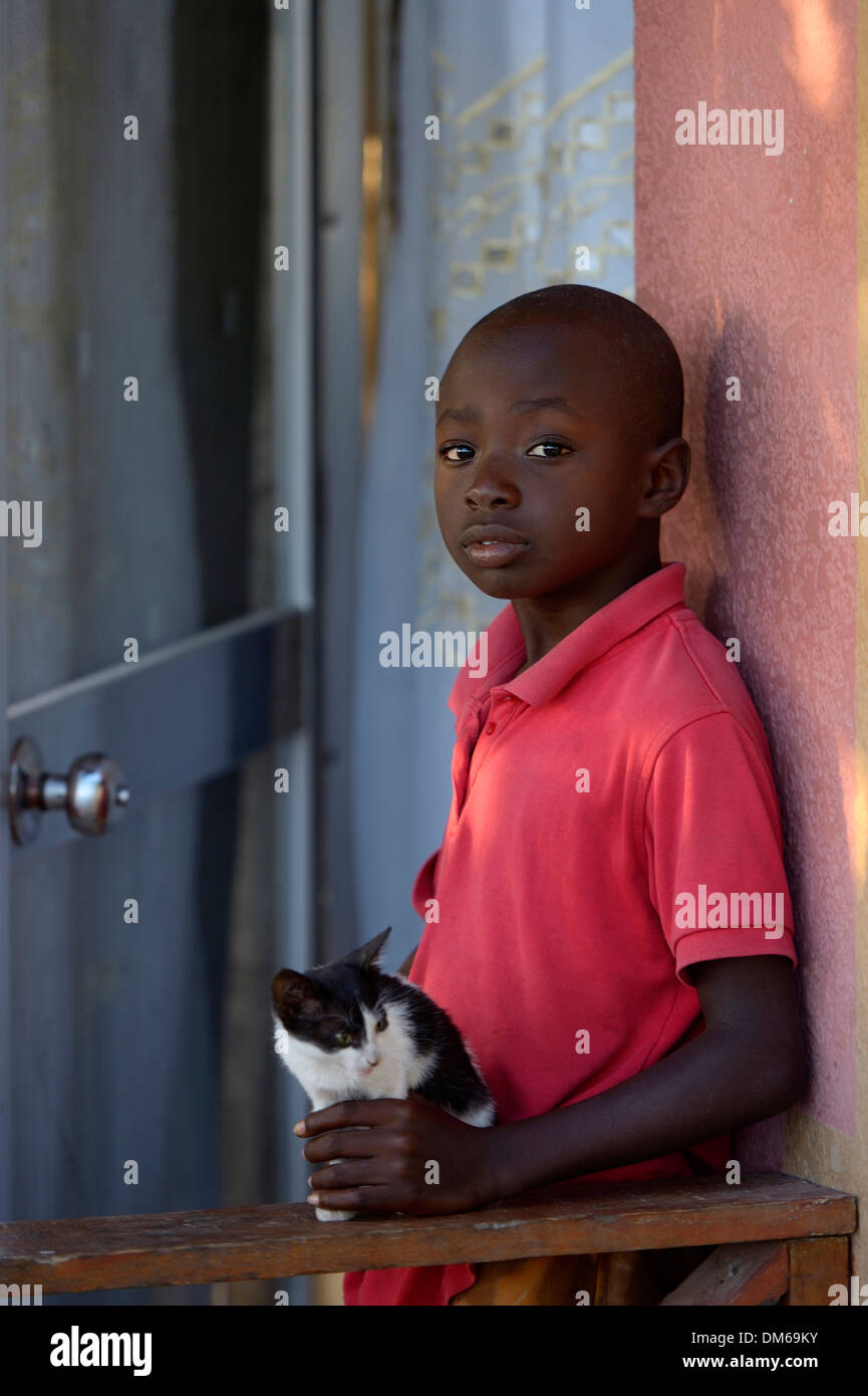Boy, 9 years, with a small cat, Tchawa, Leogane, Haiti Stock Photo