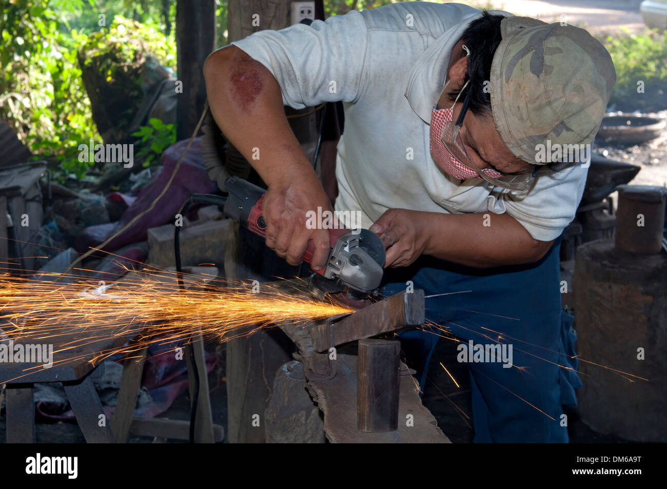 Metal worker grinding in a metalworking shop, Battambang, Cambodia Stock Photo
