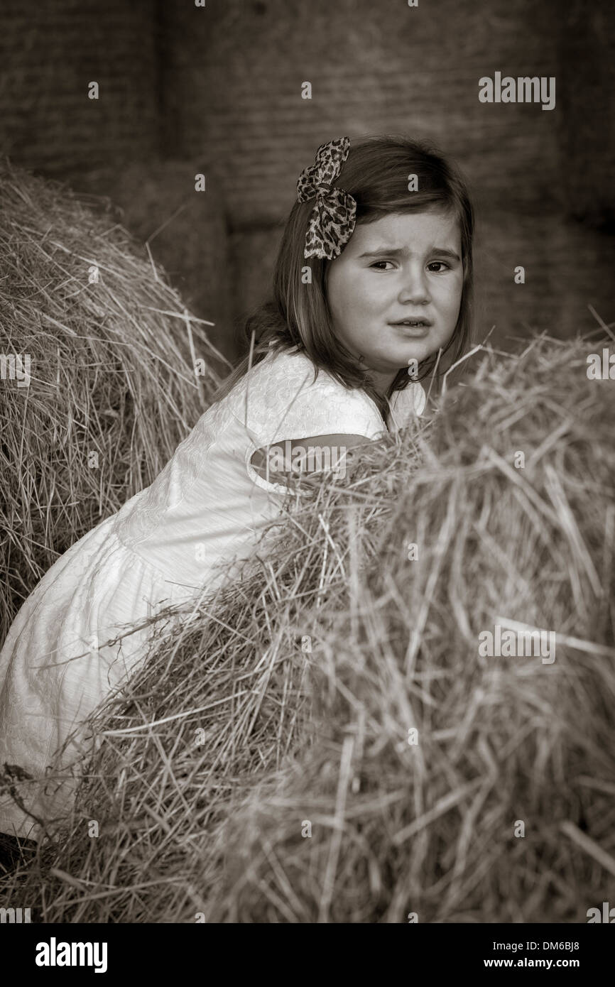 Young Girl in white dress amongst Hay bales in a Barn Stock Photo - Alamy
