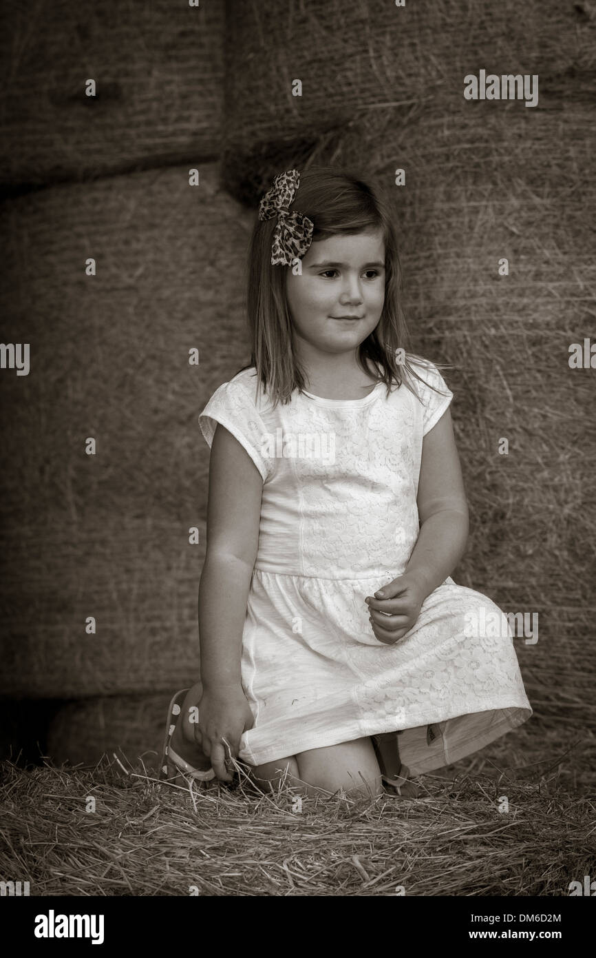 Young Girl in white dress amongst Hay bales in a Barn Stock Photo - Alamy