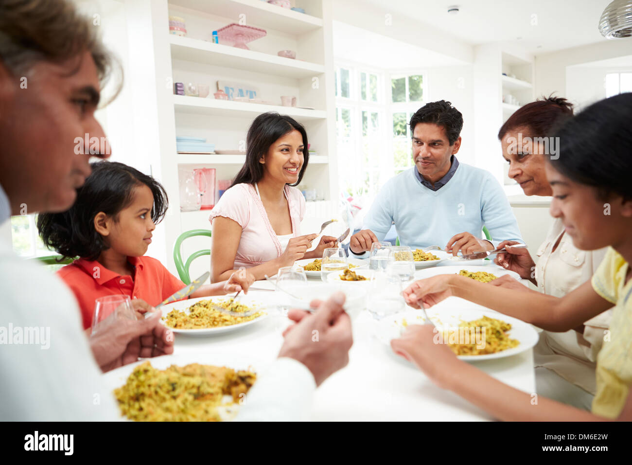 Multi Generation Indian Family Eating Meal At Home Stock Photo