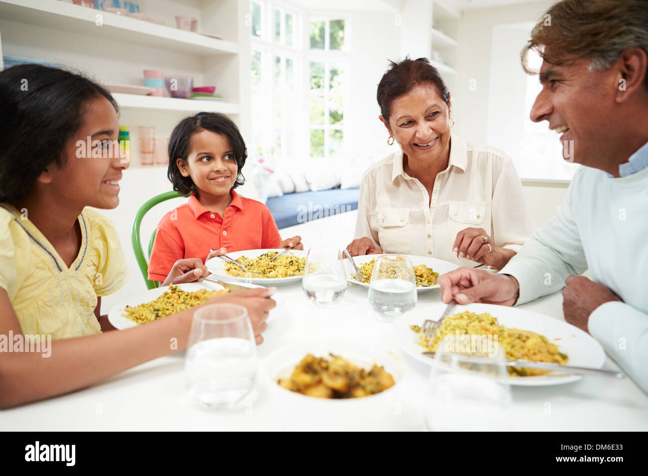 Indian Grandparents And Grandchildren Eating Meal At Home Stock Photo